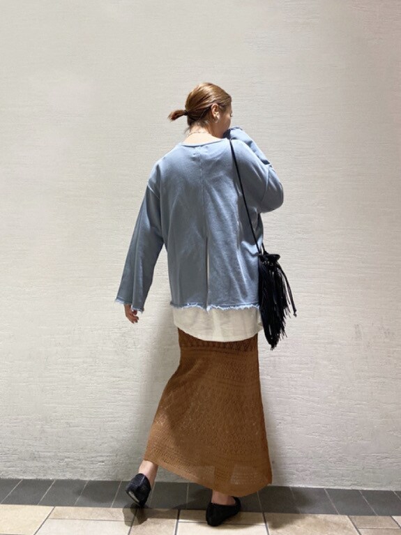 ブラック系のハンドバッグ、ブラウン系のスカート、ブラック系のTシャツ/カットソーを着用したレディースの春コーディネートの3枚目の写真