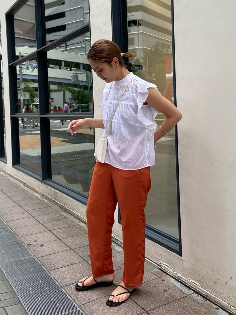 ホワイト系のシャツ/ブラウス、オレンジ系のその他パンツを着用したレディースの夏コーディネートの2枚目の写真