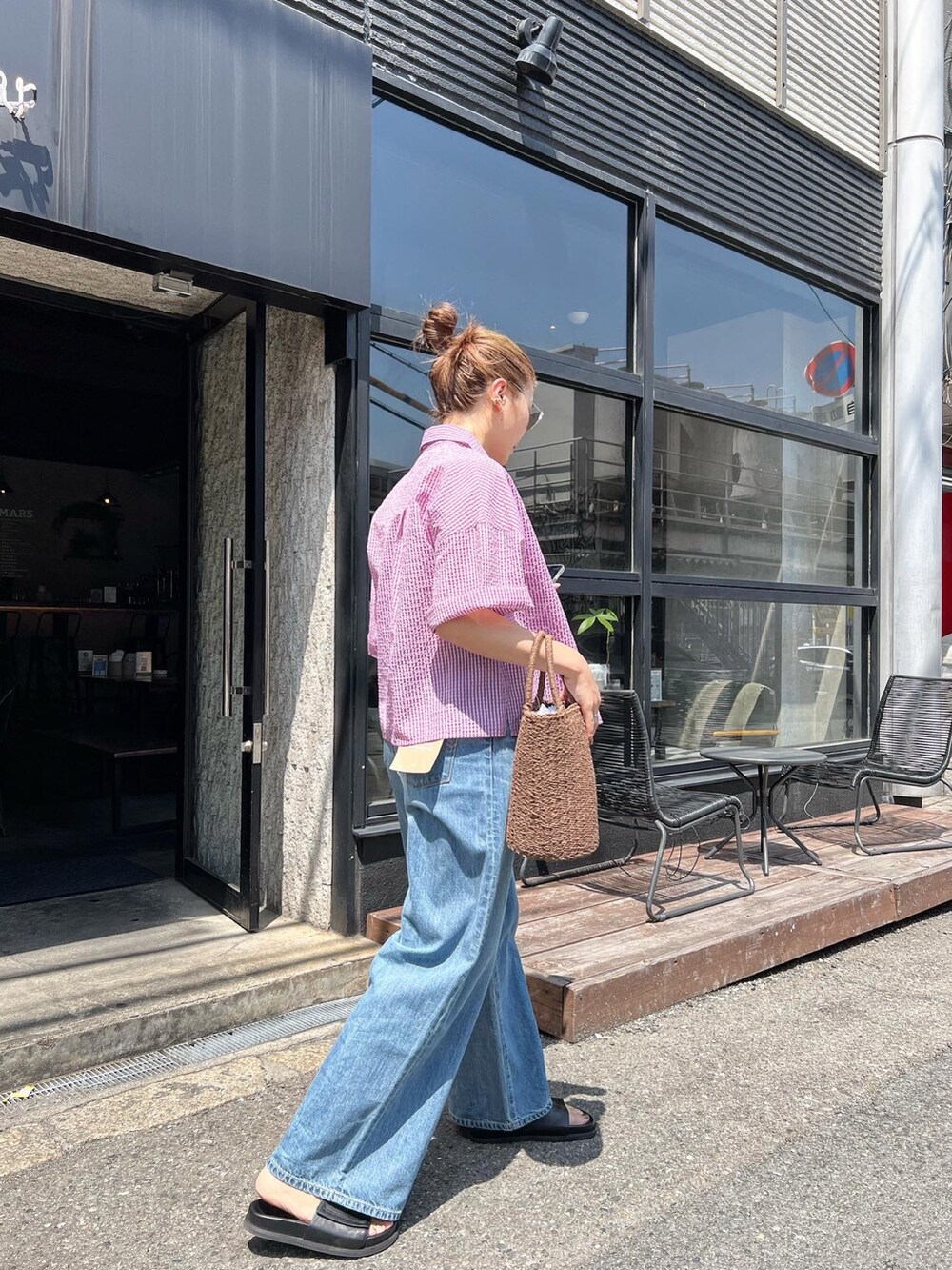 パープル系のシャツ/ブラウス、ブルー系のデニムパンツ、ブラウン系のかごバッグを着用したレディースの春コーディネートの5枚目の写真