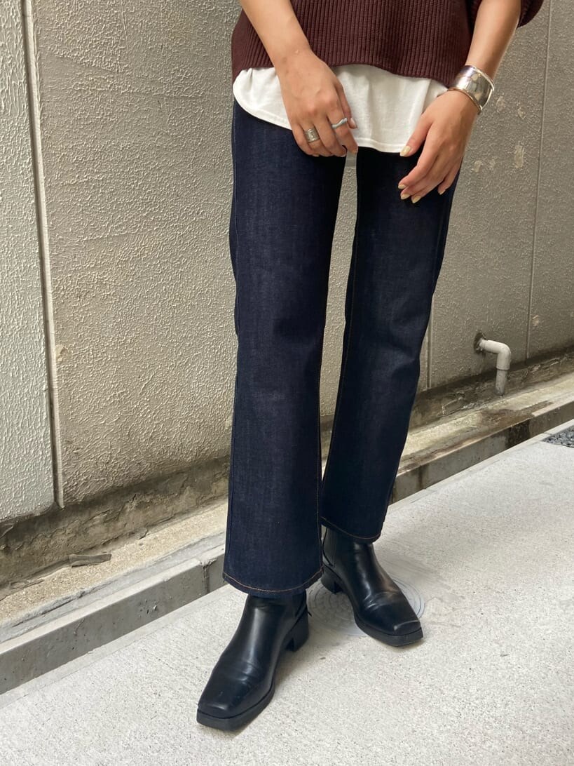 ブルー系のデニムパンツ、ブラウン系のニット/セーター、ホワイト系のTシャツ/カットソーを着用したレディースの夏コーディネートの4枚目の写真