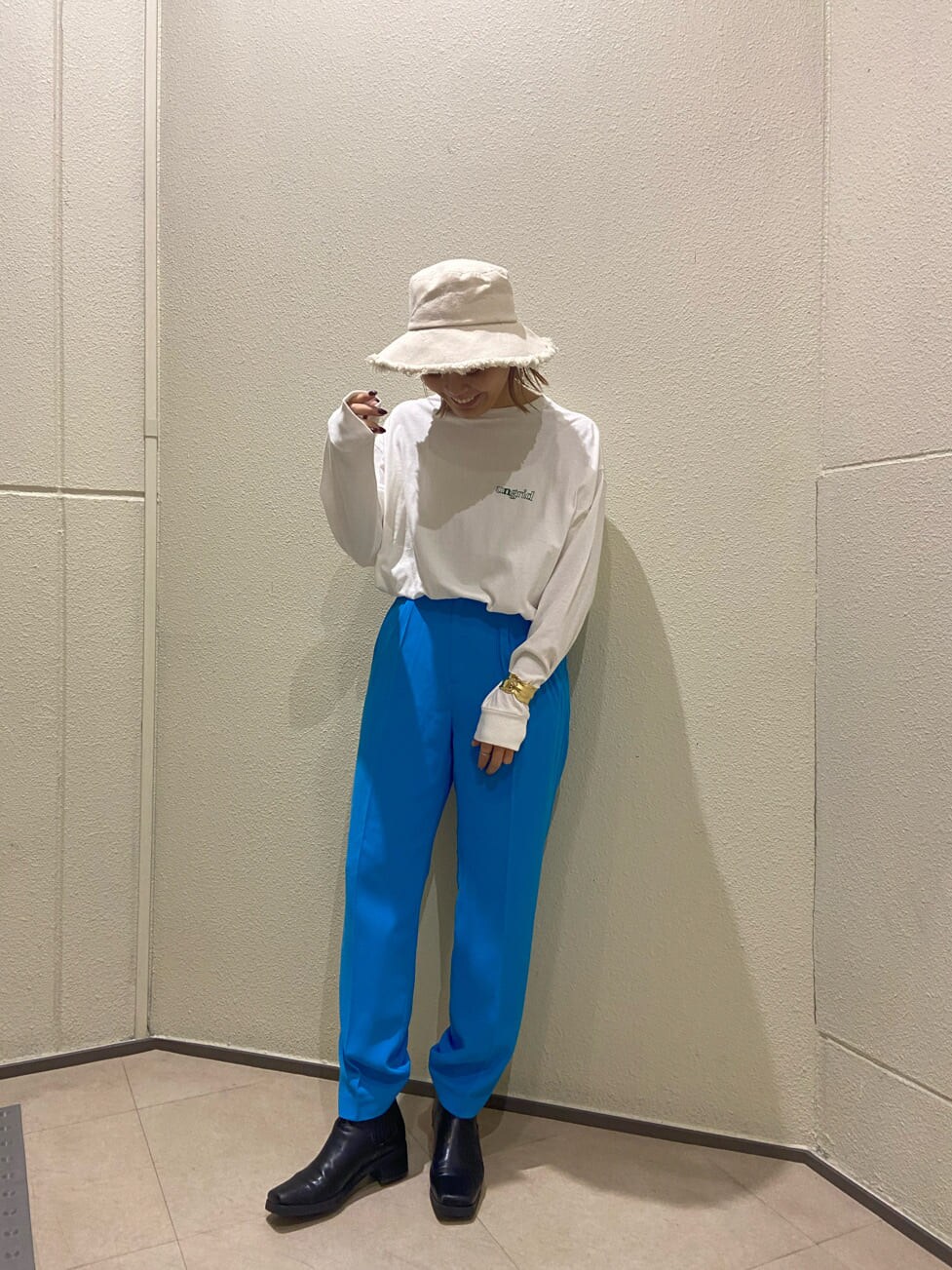 ホワイト系のTシャツ/カットソー、ブルー系のスラックス、ホワイト系のハットを着用したレディースの冬コーディネートの2枚目の写真