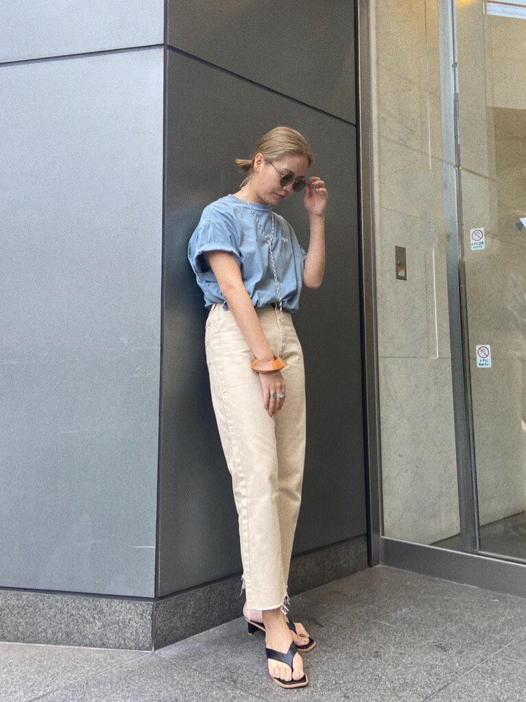 ホワイト系のデニムパンツ、ホワイト系のサンダル、ブルー系のTシャツ/カットソーを着用したレディースの春コーディネートの2枚目の写真