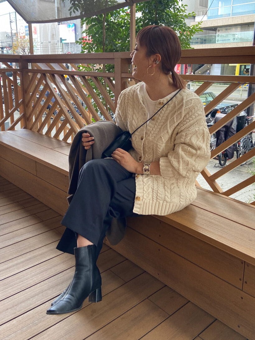 ブラック系のショルダーバッグ、ホワイト系のカーディガン/ボレロ、グレー系のその他パンツを着用したレディースの冬コーディネートの3枚目の写真