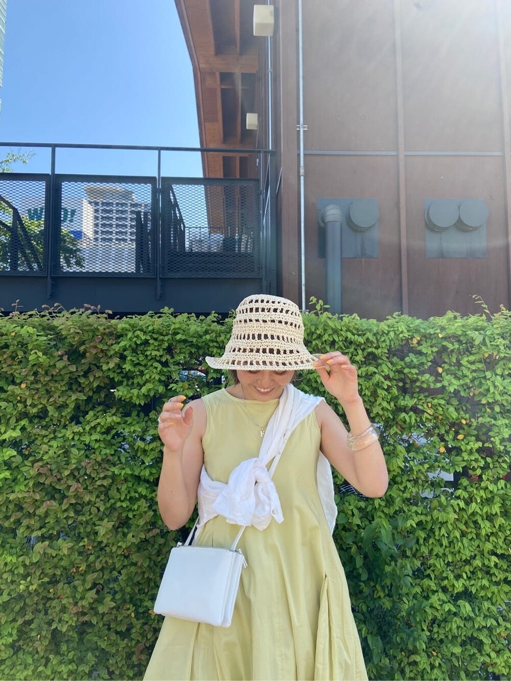 ブルー系のデニムパンツ、ホワイト系のシャツ/ブラウス、グリーン系のワンピースを着用したレディースの春コーディネートの3枚目の写真