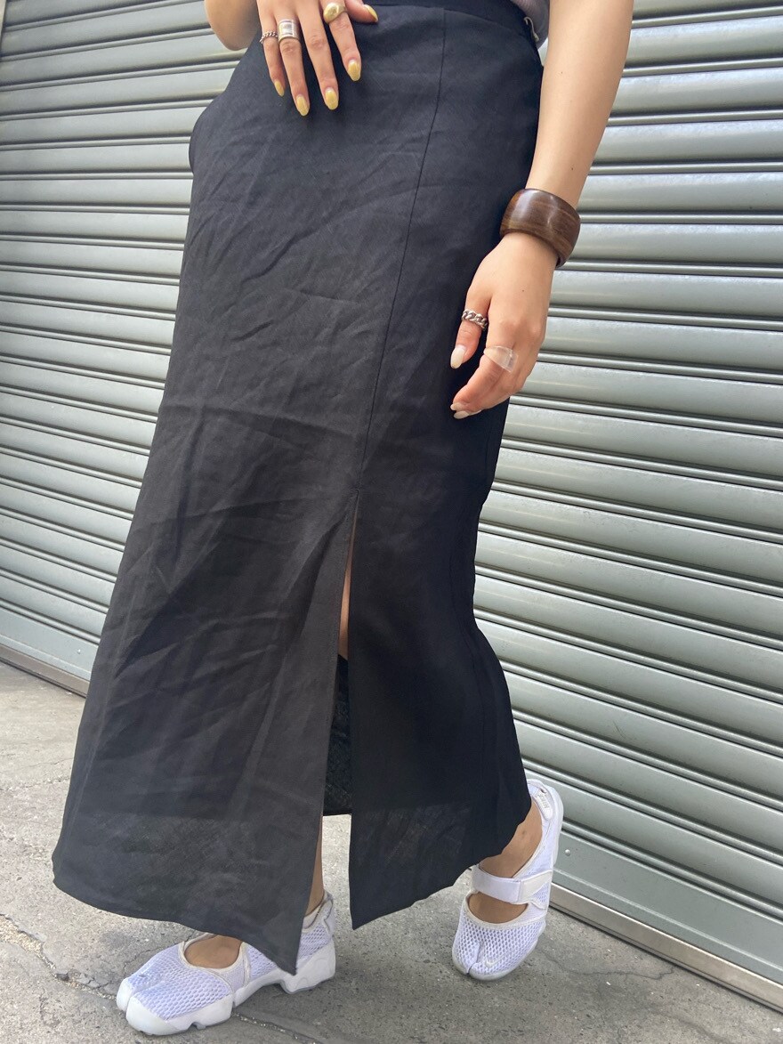 ブラック系のスカート、ブラウン系のブレスレットを着用したレディースの春コーディネートの4枚目の写真