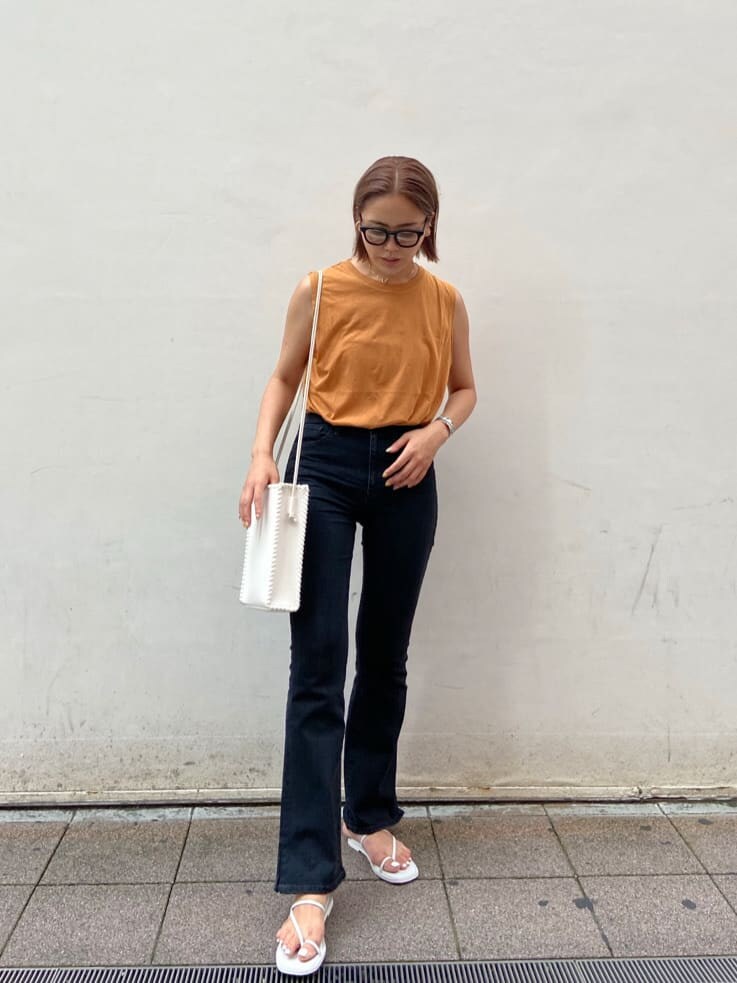 ブラック系のデニムパンツ、ホワイト系のサンダル、ホワイト系のハンドバッグを着用したレディースの夏コーディネートの4枚目の写真