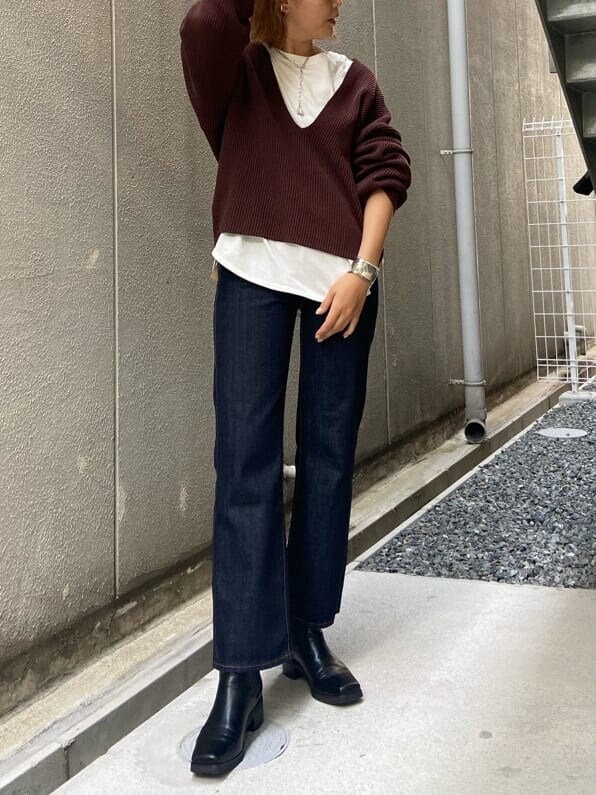 ブルー系のデニムパンツ、ブラウン系のニット/セーター、ホワイト系のTシャツ/カットソーを着用したレディースの夏コーディネートの3枚目の写真