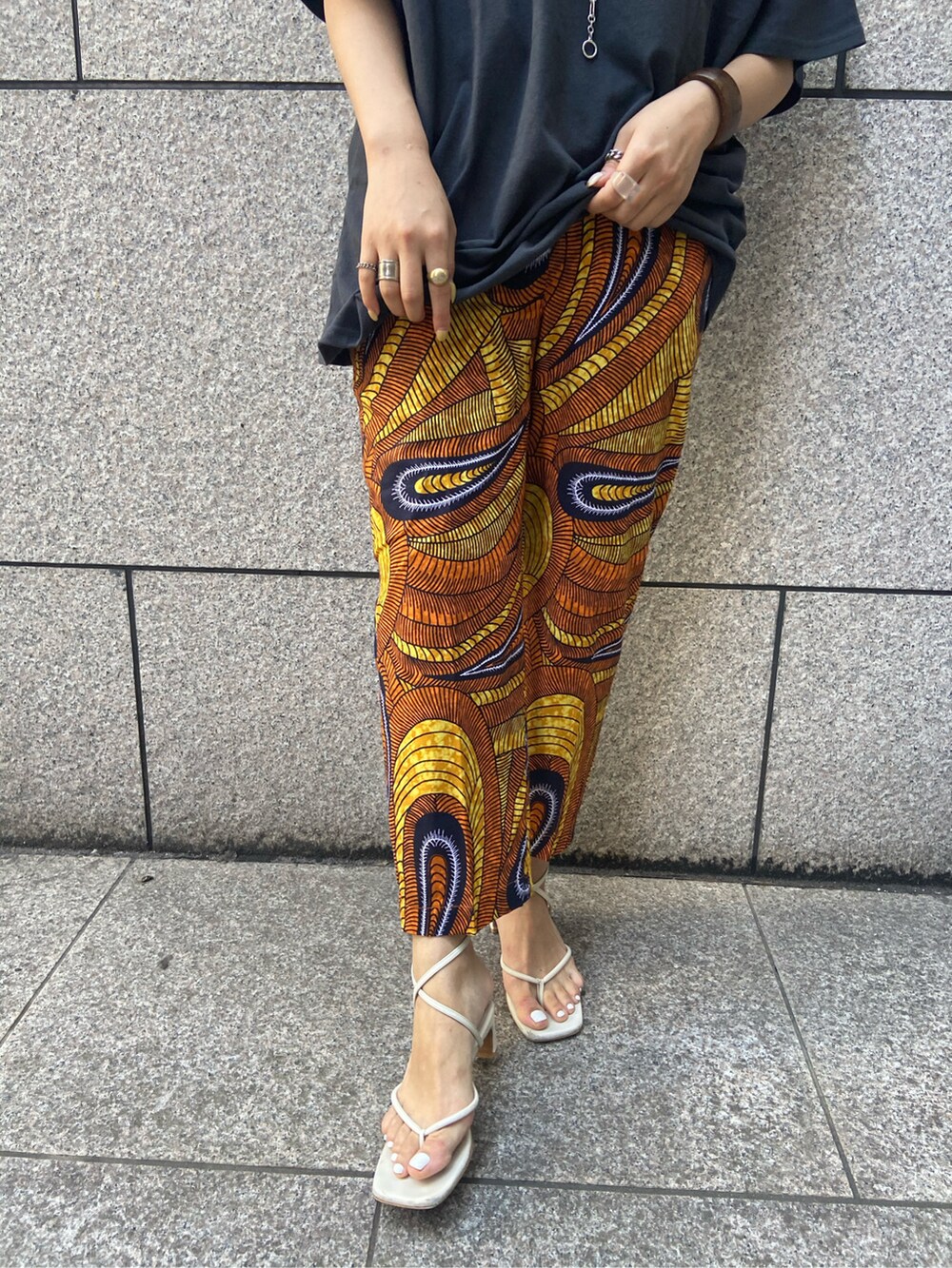 オレンジ系のその他パンツ、グレー系のTシャツ/カットソーを着用したレディースの春コーディネートの2枚目の写真