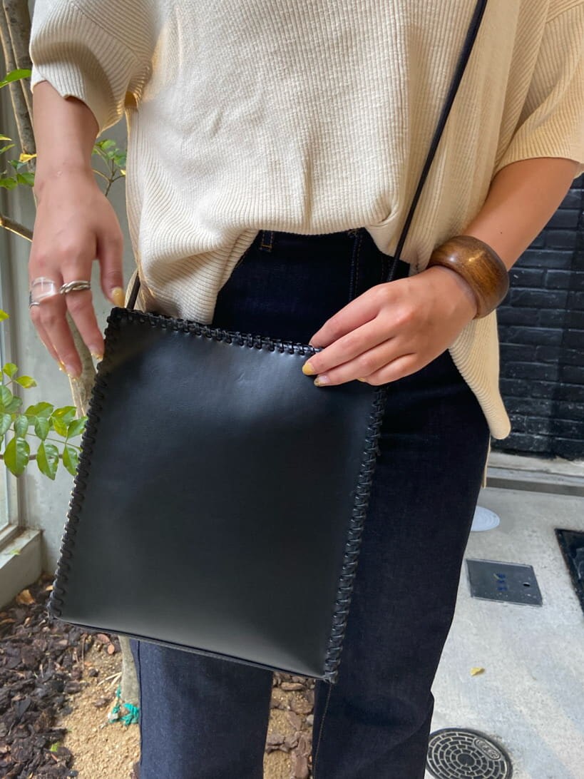 ホワイト系のサンダル、ホワイト系のニット/セーター、ブルー系のデニムパンツを着用したレディースの夏コーディネートの3枚目の写真