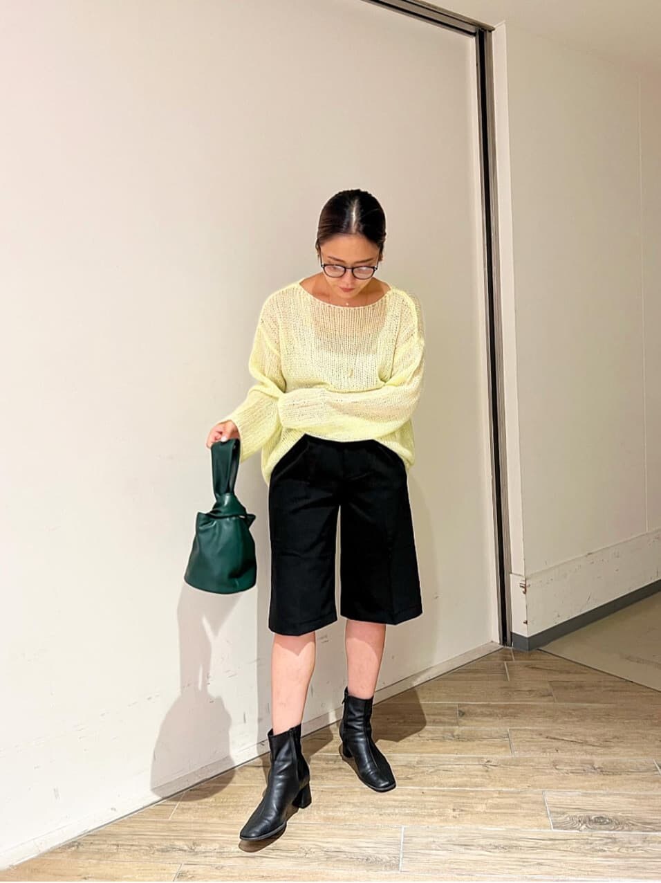 イエロー系のニット/セーター、ブラック系のその他パンツ、ブラック系のブーツを着用したレディースの秋コーディネートの2枚目の写真