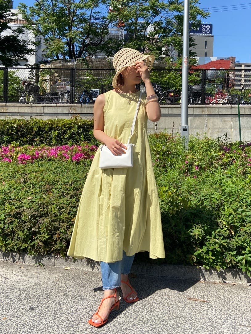 ブルー系のデニムパンツ、ホワイト系のシャツ/ブラウス、グリーン系のワンピースを着用したレディースの春コーディネートの4枚目の写真