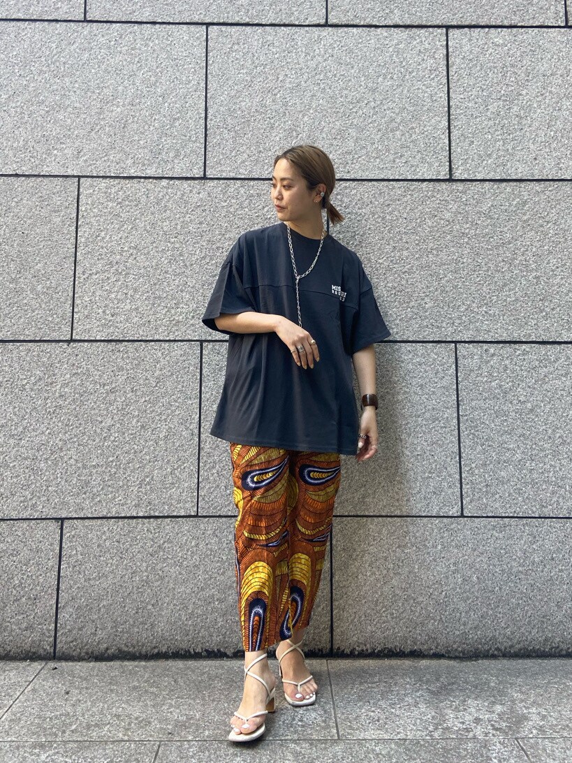 オレンジ系のその他パンツ、グレー系のTシャツ/カットソーを着用したレディースの春コーディネートの3枚目の写真