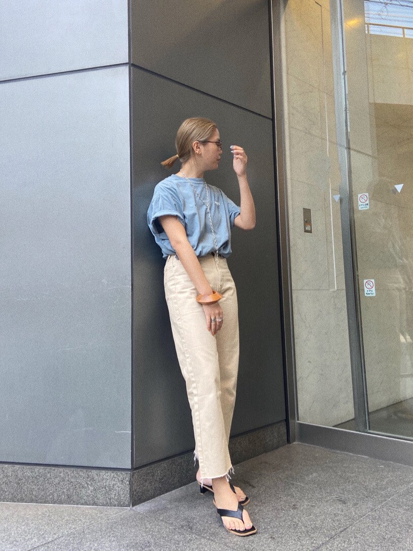 ホワイト系のデニムパンツ、ホワイト系のサンダル、ブルー系のTシャツ/カットソーを着用したレディースの春コーディネートの3枚目の写真