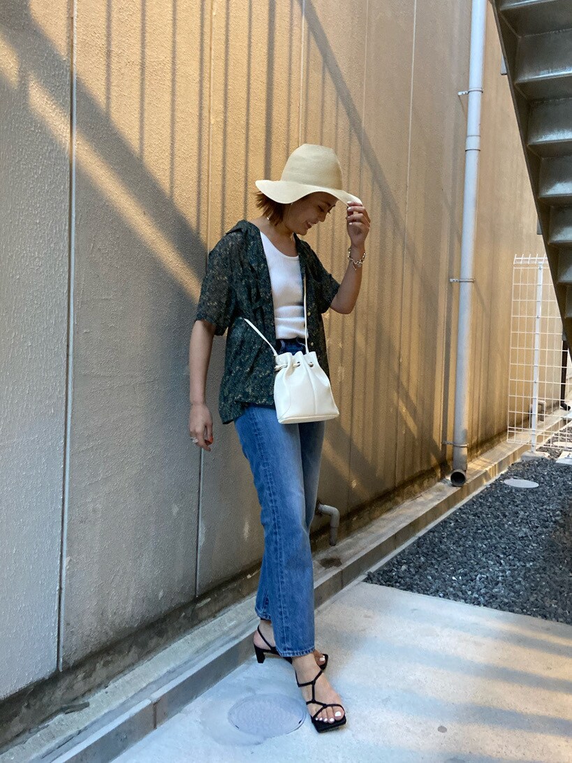 ブラック系のサンダル、ブルー系のデニムパンツ、レッド系のシャツ/ブラウスを着用したレディースの夏コーディネートの3枚目の写真