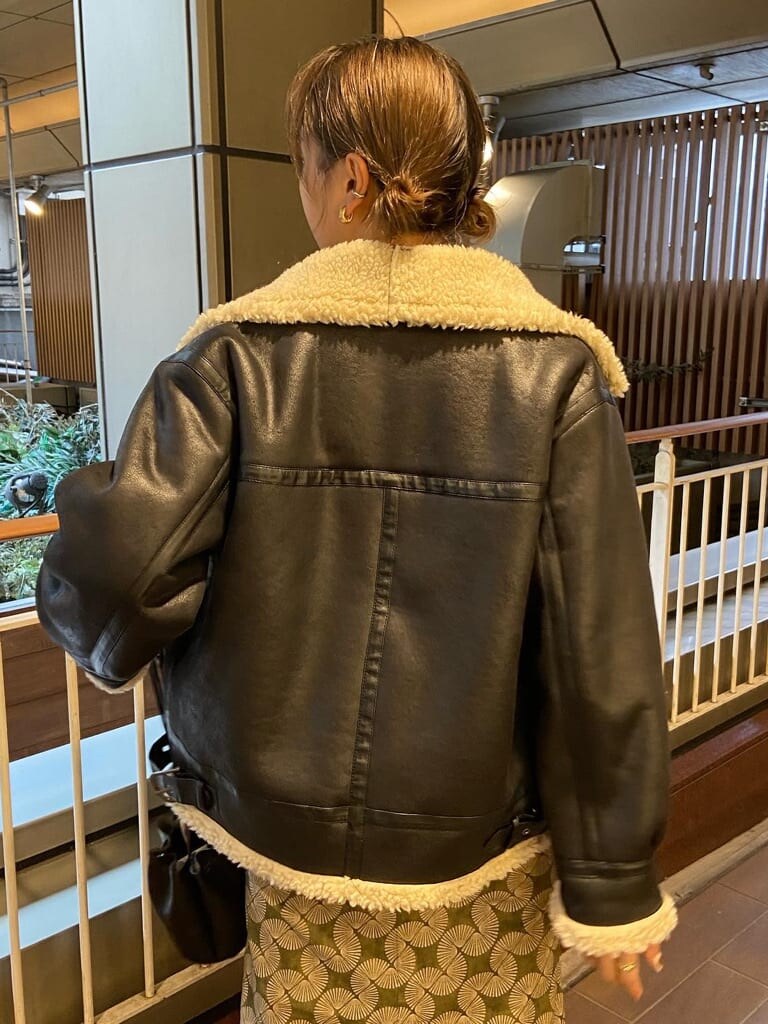 ブラック系のブルゾン、ブラック系のブーツ、ブラック系のハンドバッグを着用したレディースの秋コーディネートの3枚目の写真