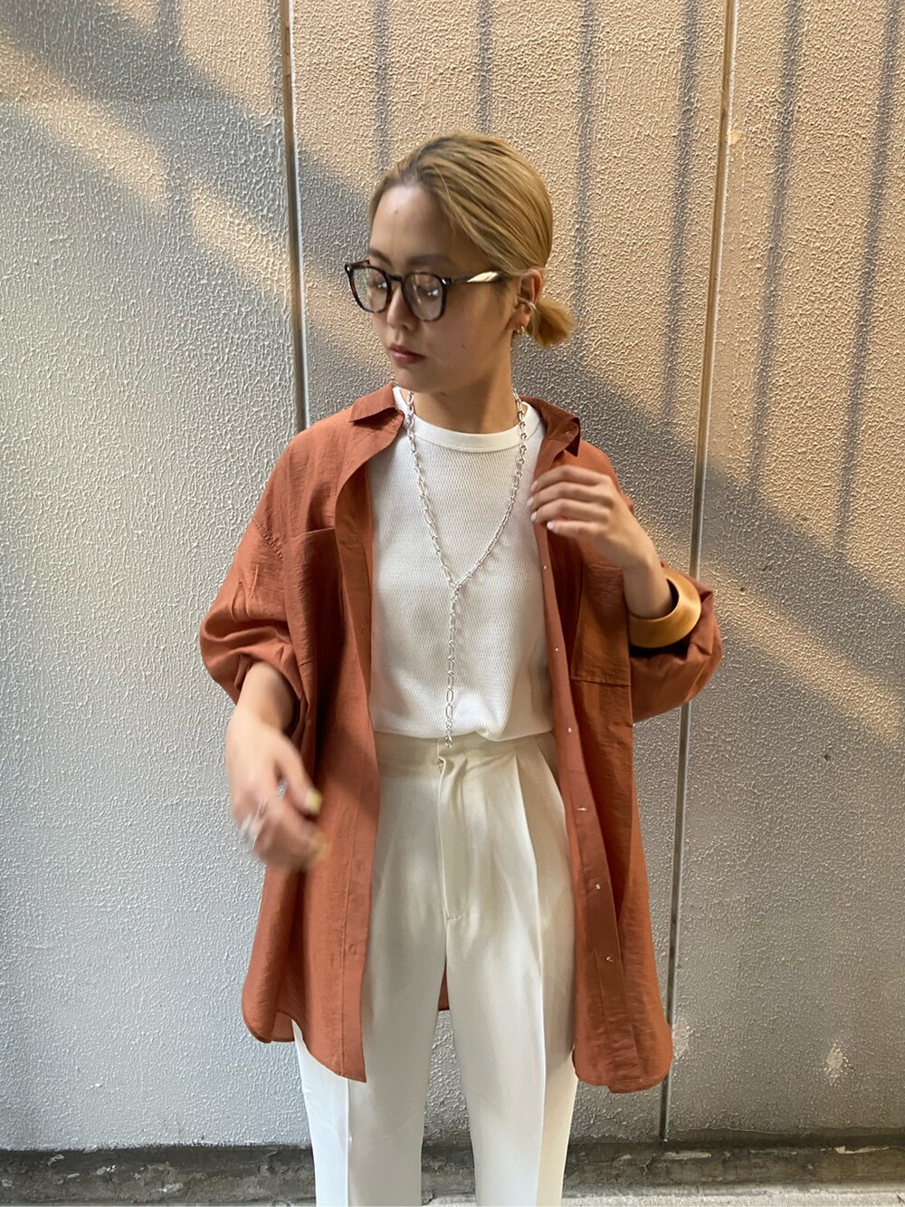 オレンジ系のシャツ/ブラウス、ホワイト系のその他パンツ、ホワイト系のタンクトップを着用したレディースの春コーディネートの3枚目の写真