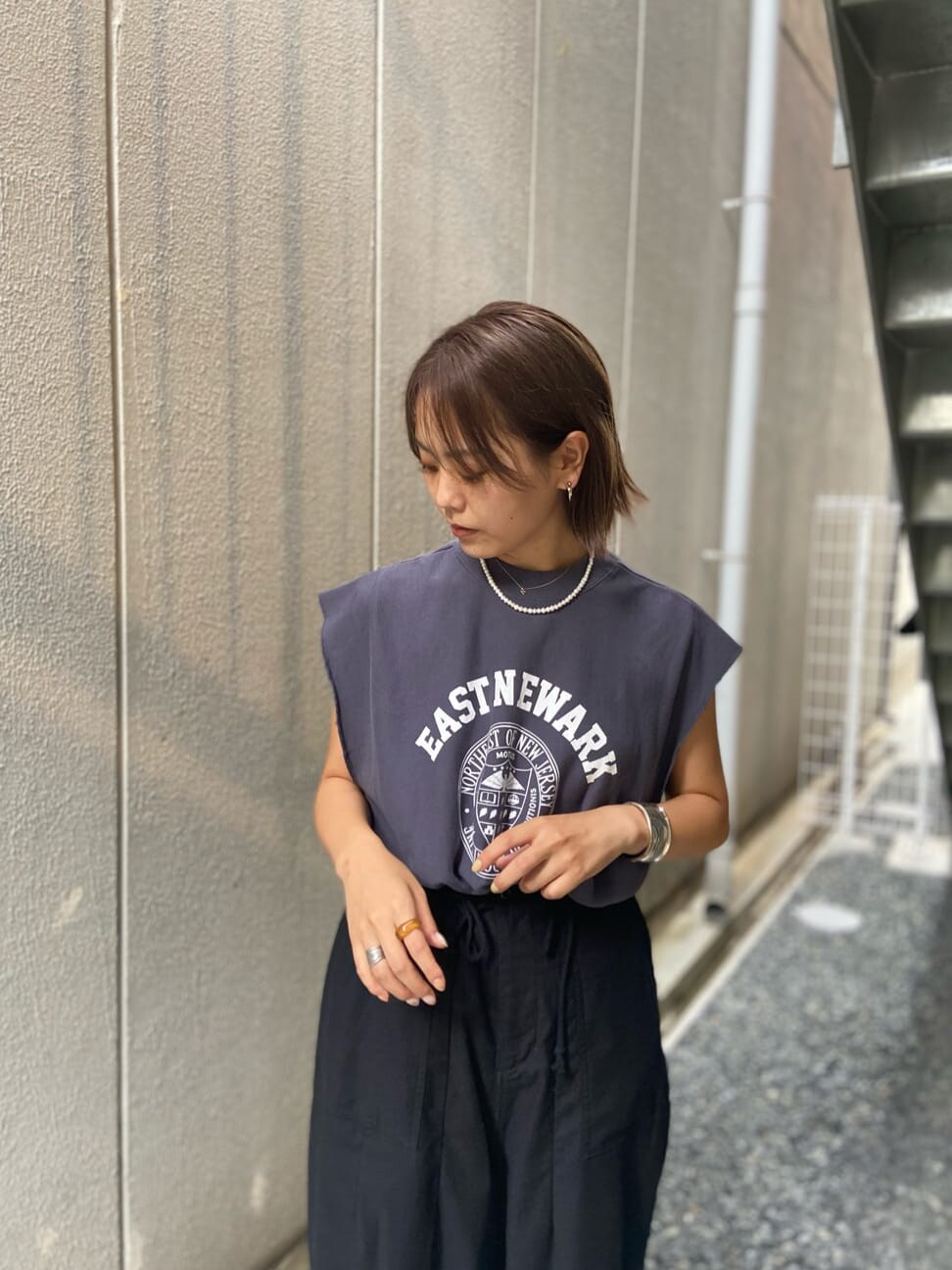 ベージュ系のトレンチコート、ブラック系のその他パンツ、ホワイト系のブーツを着用したレディースの夏コーディネートの5枚目の写真