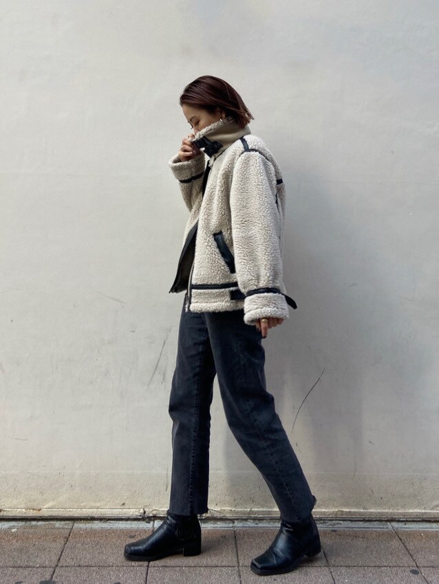 ベージュ系のムートンコートを着用したレディースの冬コーディネートの2枚目の写真