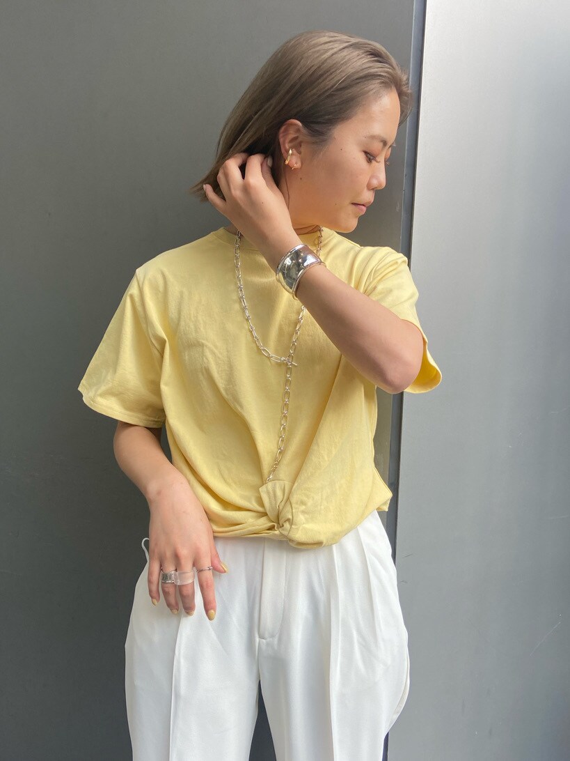 ホワイト系のハンドバッグ、ホワイト系のその他パンツ、イエロー系のTシャツ/カットソーを着用したレディースの春コーディネートの2枚目の写真