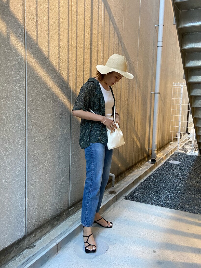 ブラック系のサンダル、ブルー系のデニムパンツ、レッド系のシャツ/ブラウスを着用したレディースの夏コーディネートの2枚目の写真