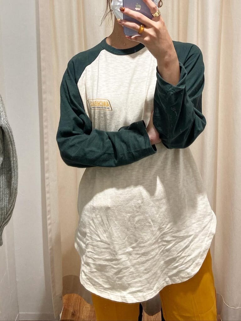 イエロー系のその他パンツ、グリーン系のTシャツ/カットソー、ベージュ系のステンカラーコートを着用したレディースの秋コーディネートの4枚目の写真
