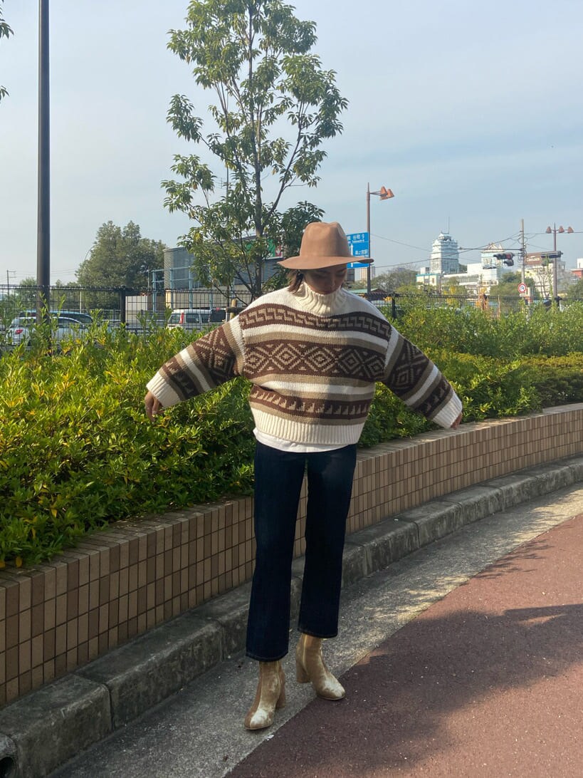 ホワイト系のニット/セーター、ホワイト系のTシャツ/カットソー、ゴールド系のブーツを着用したレディースの秋コーディネートの3枚目の写真