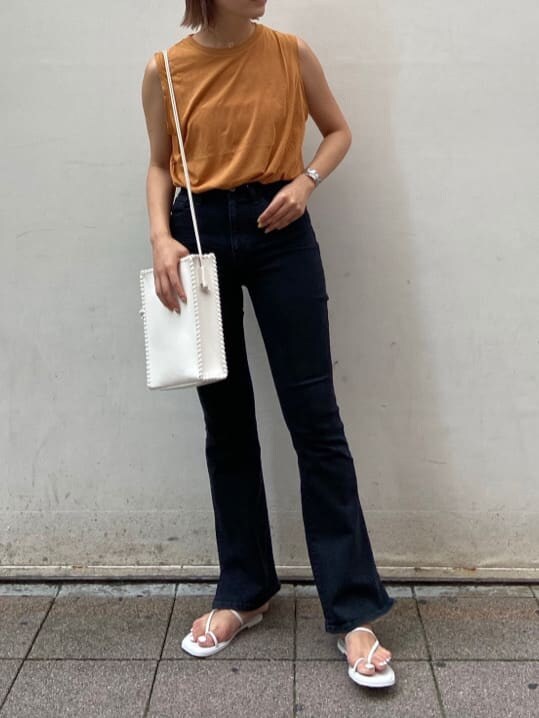 ブラック系のデニムパンツ、ホワイト系のサンダル、ホワイト系のハンドバッグを着用したレディースの夏コーディネートの3枚目の写真