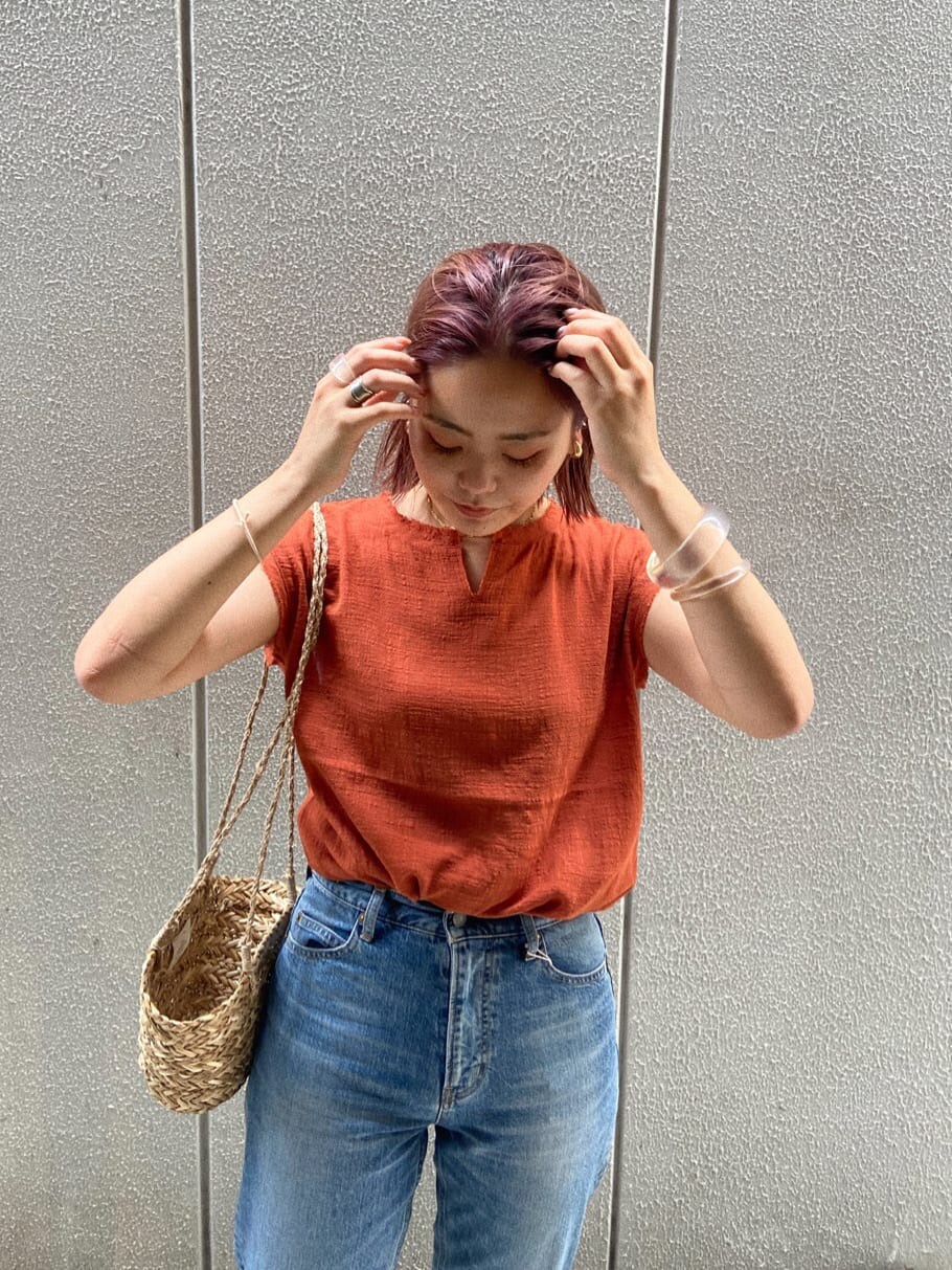 ブルー系のデニムパンツ、オレンジ系のシャツ/ブラウスを着用したレディースの夏コーディネートの2枚目の写真