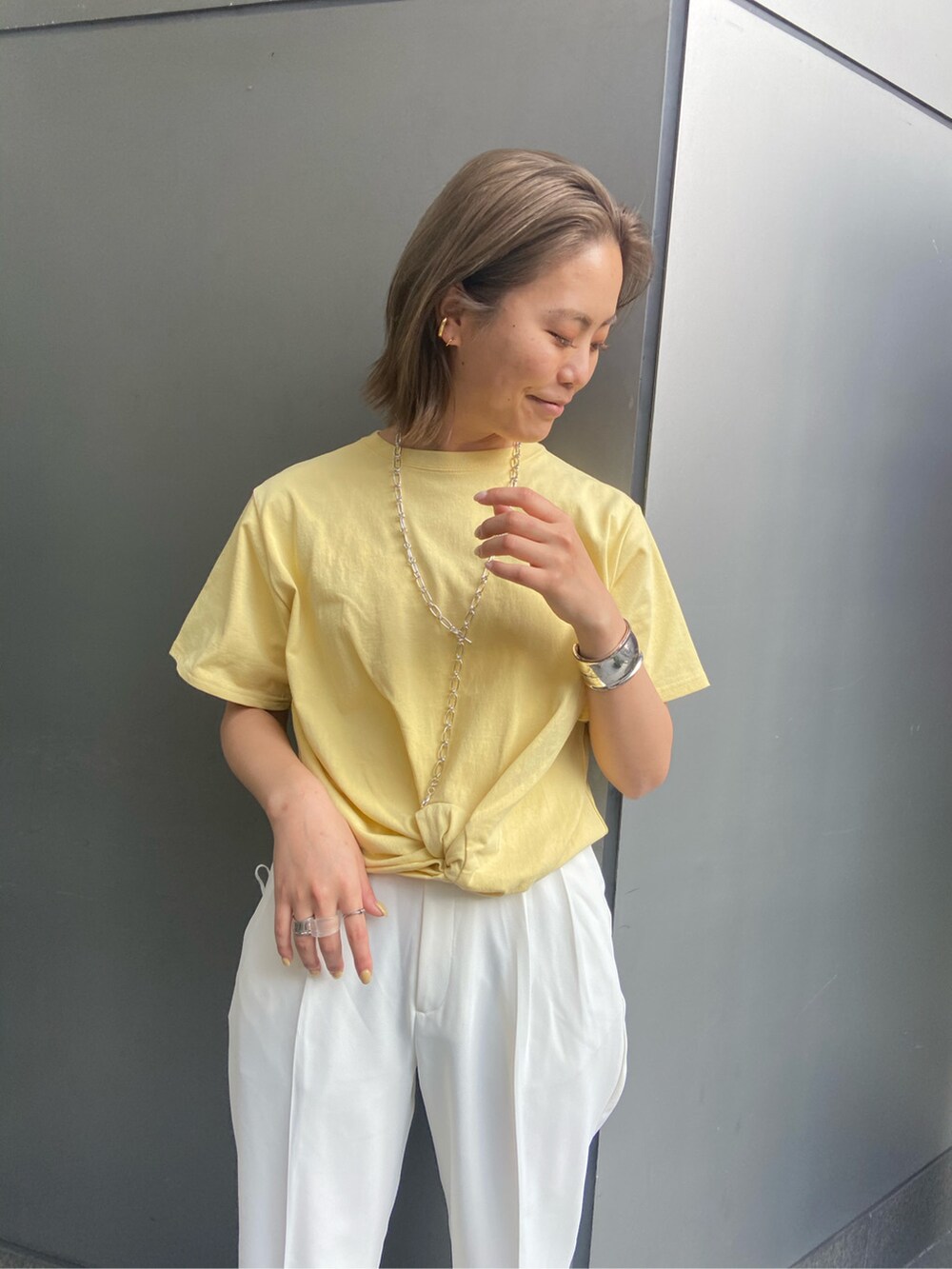 ホワイト系のハンドバッグ、ホワイト系のその他パンツ、イエロー系のTシャツ/カットソーを着用したレディースの春コーディネートの3枚目の写真