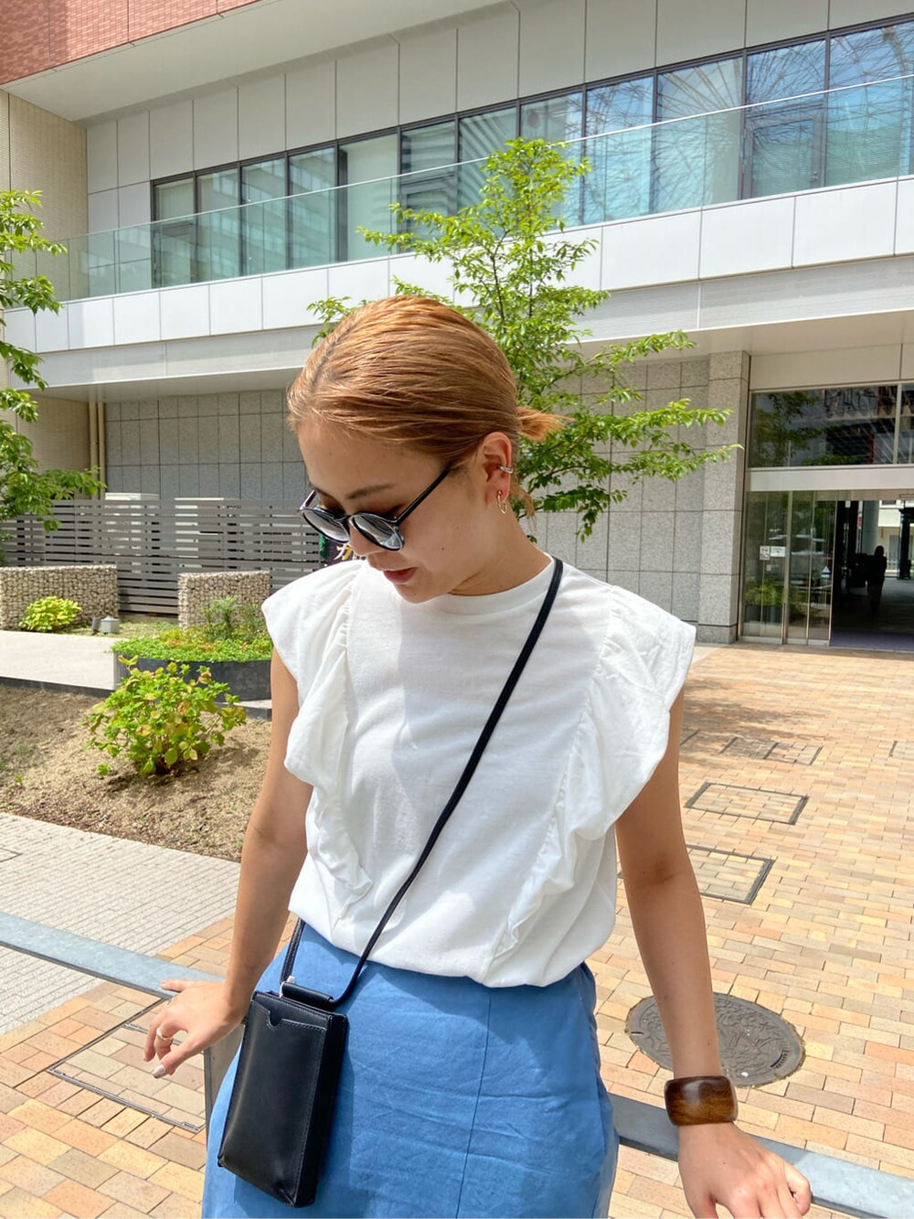 ブルー系のスカート、ホワイト系のTシャツ/カットソーを着用したレディースの夏コーディネートの2枚目の写真