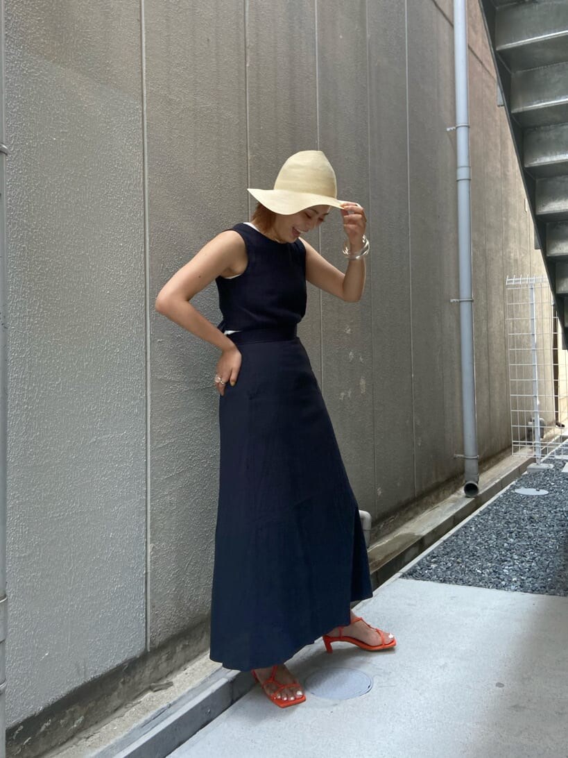 オレンジ系のサンダル、ブラック系のワンピースを着用したレディースの夏コーディネートの3枚目の写真