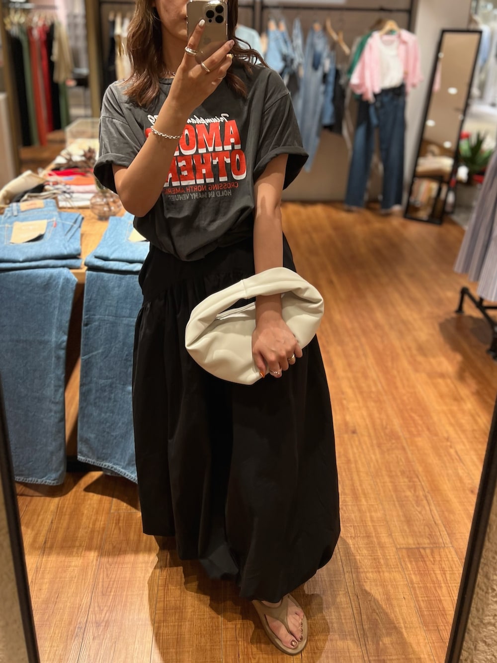 ホワイト系のハンドバッグ、グレー系のTシャツ/カットソー、ブラック系のワンピースを着用したレディースの夏コーディネートの2枚目の写真