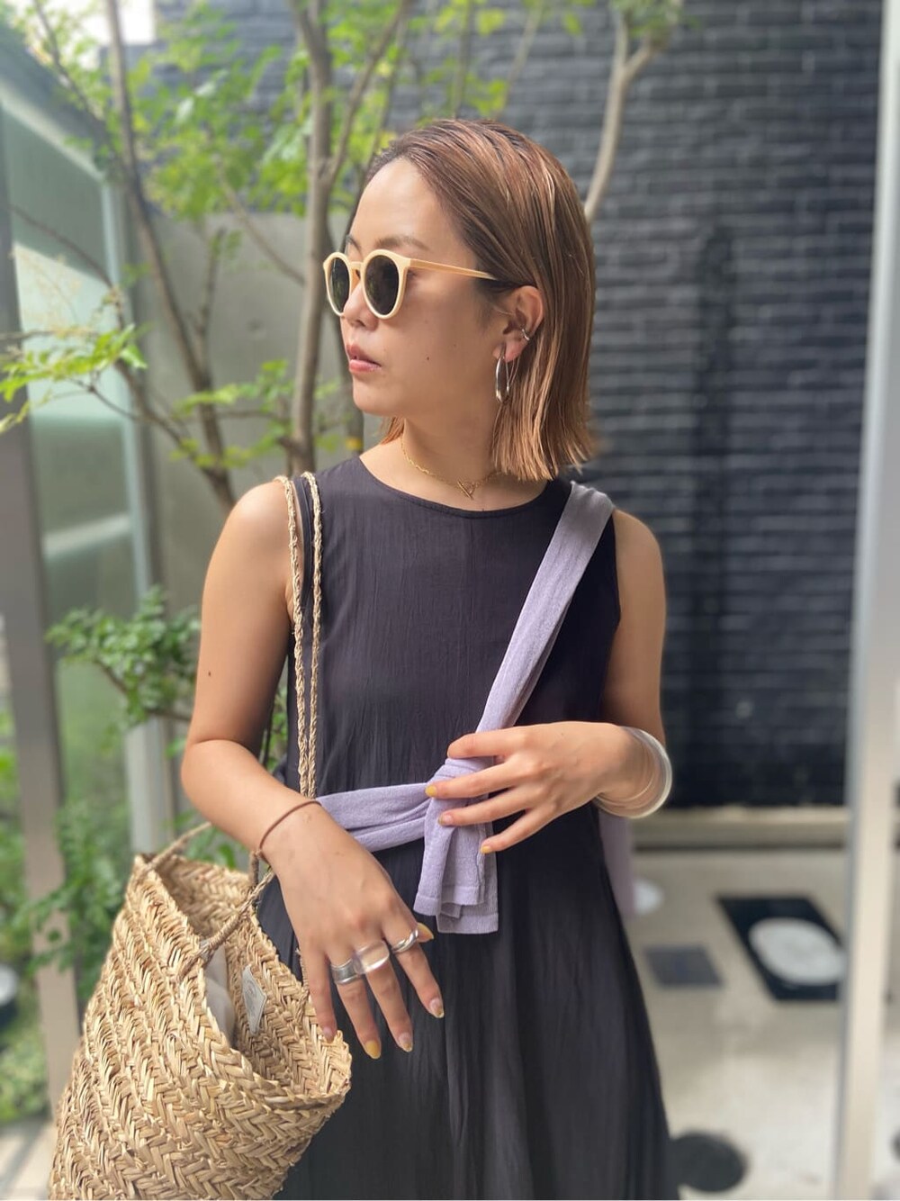パープル系のニット/セーター、ベージュ系のかごバッグ、ブラック系のワンピースを着用したレディースの夏コーディネートの3枚目の写真