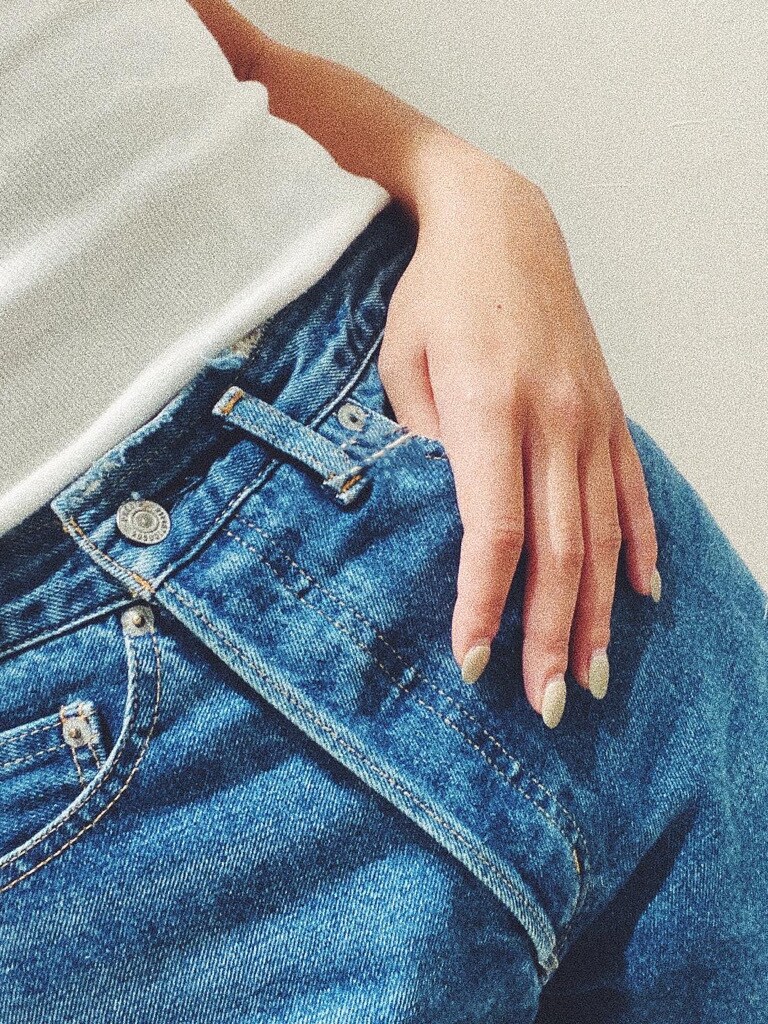 ホワイト系のTシャツ/カットソー、ブルー系のデニムパンツ、グリーン系のニット/セーターを着用したレディースの秋コーディネートの2枚目の写真