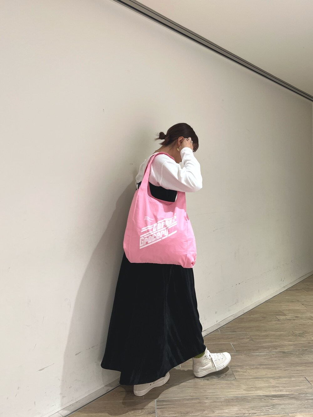 ホワイト系のスニーカー、ブラック系のワンピースを着用したレディースの冬コーディネートの3枚目の写真