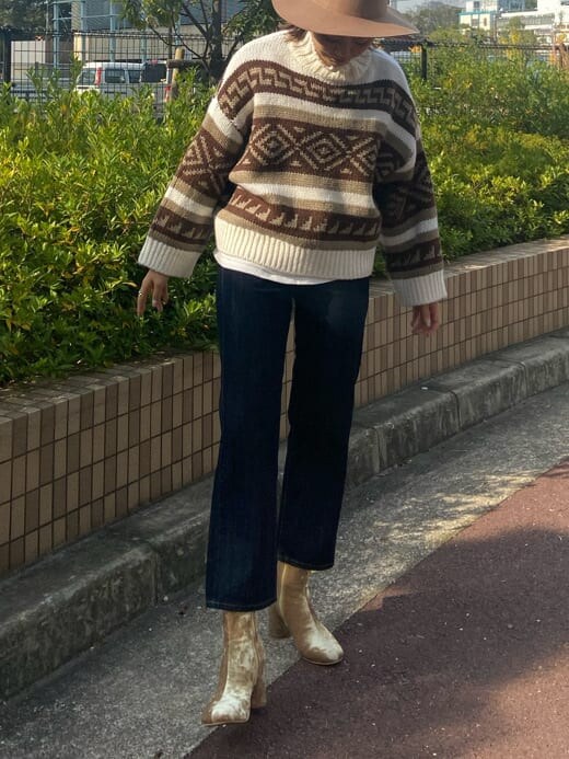 ホワイト系のニット/セーター、ホワイト系のTシャツ/カットソー、ゴールド系のブーツを着用したレディースの秋コーディネートの4枚目の写真