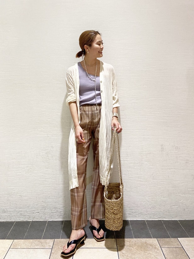 ベージュ系のその他パンツ、パープル系のタンクトップ、ホワイト系のカーディガン/ボレロを着用したレディースの春コーディネートの2枚目の写真