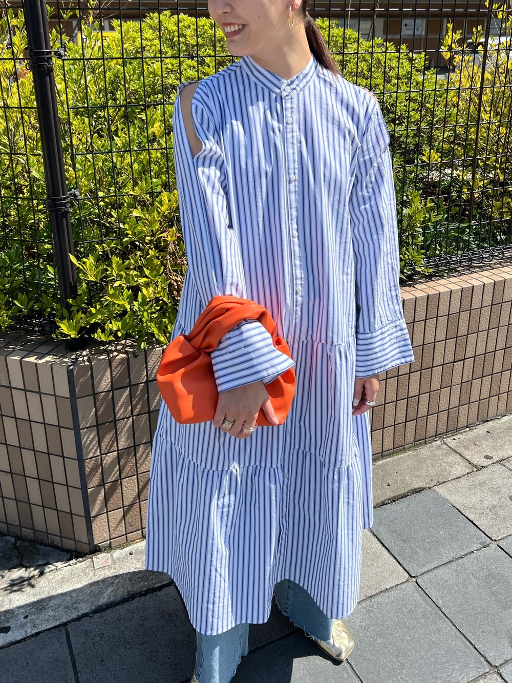 その他のワンピース、オレンジ系のハンドバッグ、ゴールド系のパンプスを着用したレディースの春コーディネートの4枚目の写真