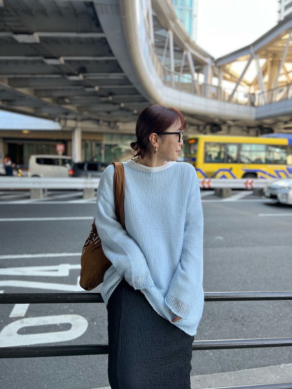 ブルー系のニット/セーター、ブラック系のスカート、ブラウン系のエコバッグ/サブバッグを着用したレディースの冬コーディネートの4枚目の写真