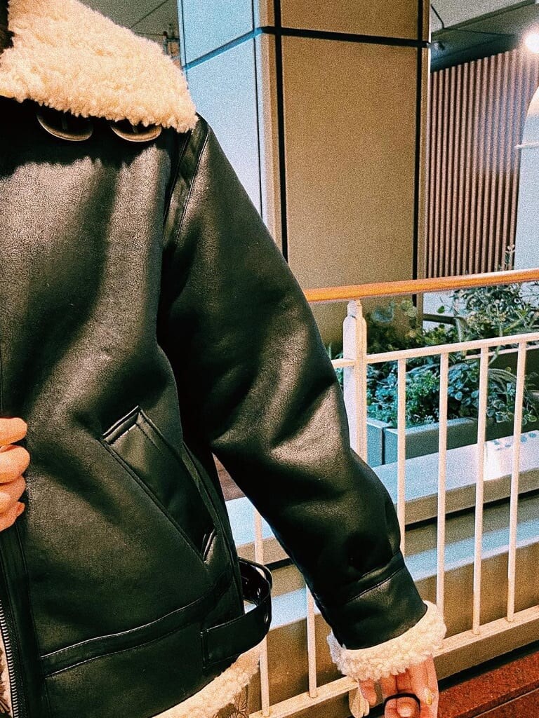 ブラック系のブルゾン、ブラック系のブーツ、ブラック系のハンドバッグを着用したレディースの秋コーディネートの4枚目の写真