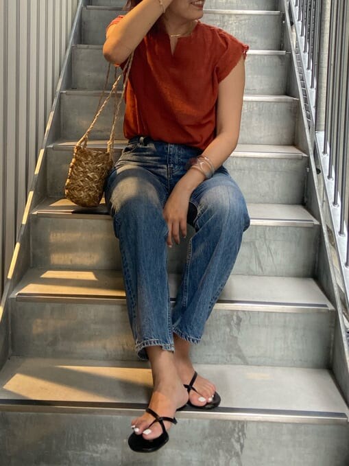 ブルー系のデニムパンツ、オレンジ系のシャツ/ブラウスを着用したレディースの夏コーディネートの3枚目の写真