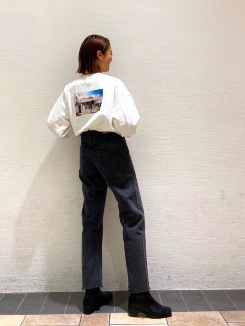 ブラック系のデニムパンツを着用したレディースの秋コーディネートの3枚目の写真