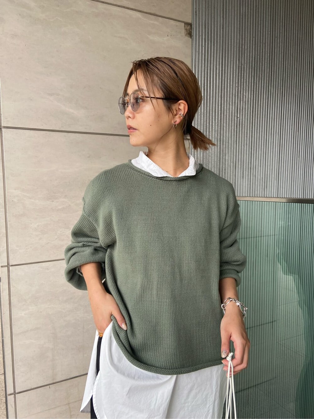 ブラック系のその他パンツ、グリーン系のニット/セーター、ブラック系のブーツを着用したレディースの秋コーディネートの2枚目の写真