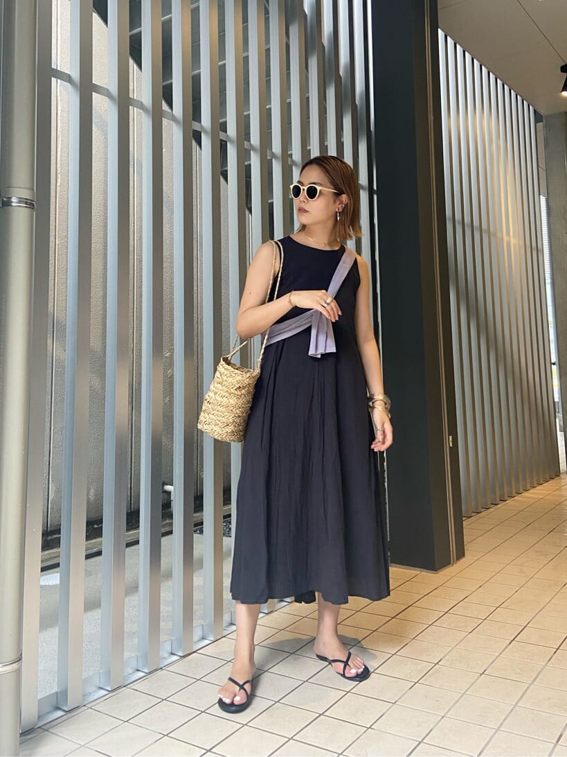 パープル系のニット/セーター、ベージュ系のかごバッグ、ブラック系のワンピースを着用したレディースの夏コーディネートの4枚目の写真