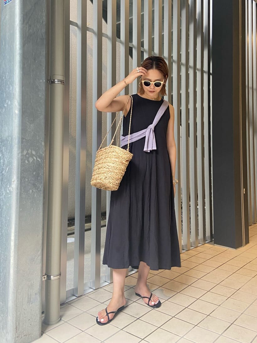 パープル系のニット/セーター、ベージュ系のかごバッグ、ブラック系のワンピースを着用したレディースの夏コーディネートの2枚目の写真
