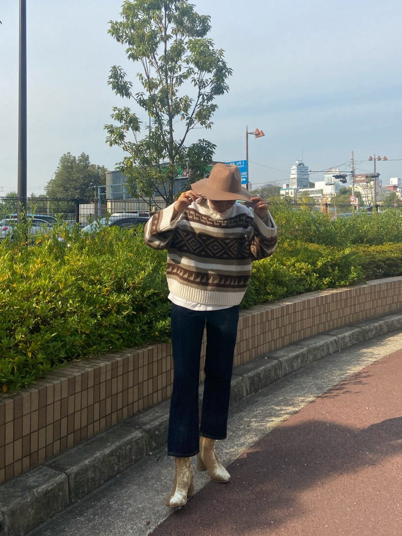 ホワイト系のニット/セーター、ホワイト系のTシャツ/カットソー、ゴールド系のブーツを着用したレディースの秋コーディネートの2枚目の写真