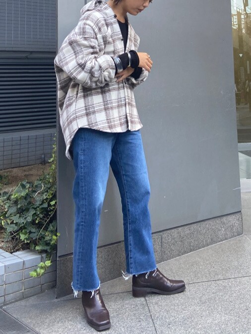 ホワイト系のシャツ/ブラウス、ブラック系のニット/セーター、ブルー系のデニムパンツを着用したレディースの秋コーディネートの3枚目の写真