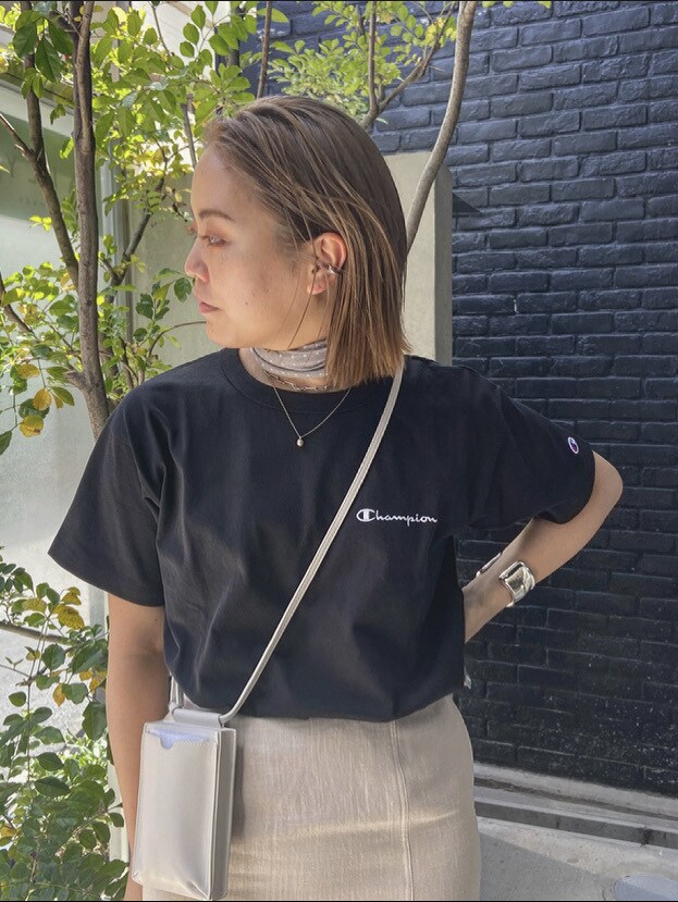 ホワイト系のスカート、ホワイト系のボディバッグ/ウエストポーチ、ブラック系のTシャツ/カットソーを着用したレディースの春コーディネートの3枚目の写真