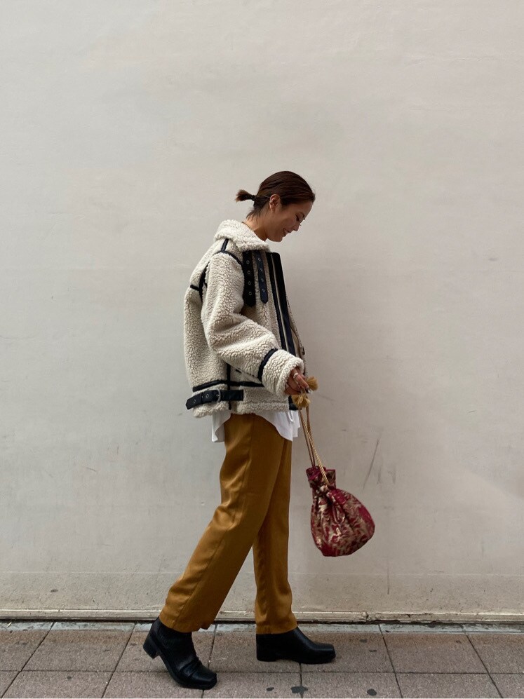 レッド系のハンドバッグ、ホワイト系のTシャツ/カットソー、ブラック系のブーツを着用したレディースの秋コーディネートの3枚目の写真