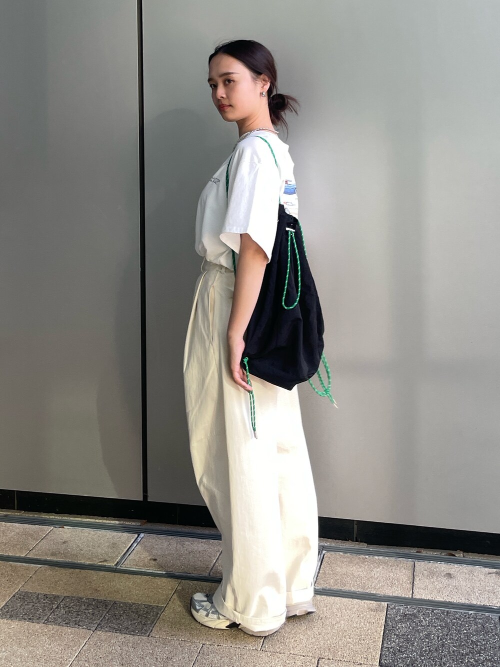 ホワイト系のTシャツ/カットソー、ホワイト系のチノパンツ、ブラック系のバックパック/リュックを着用したレディースの夏コーディネートの3枚目の写真